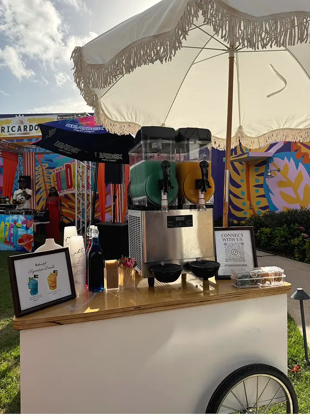 The Frozen Cart under its fringed parasol in front of a painted mural