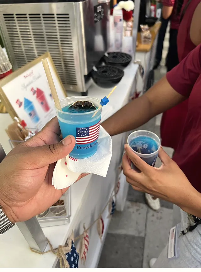 Guests holding blue frozen drinks in custom Freedom 250 cups