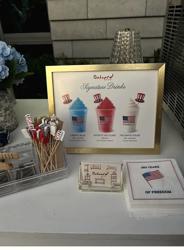 Onboard's red, white and blue signature drinks menu for Freedom 250, with themed stirrers